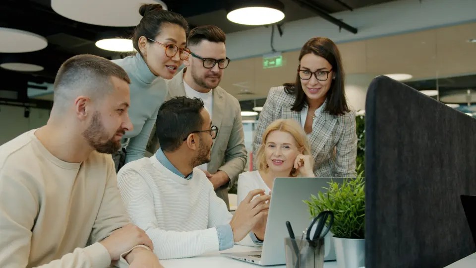 Happy team validating a project on a laptop