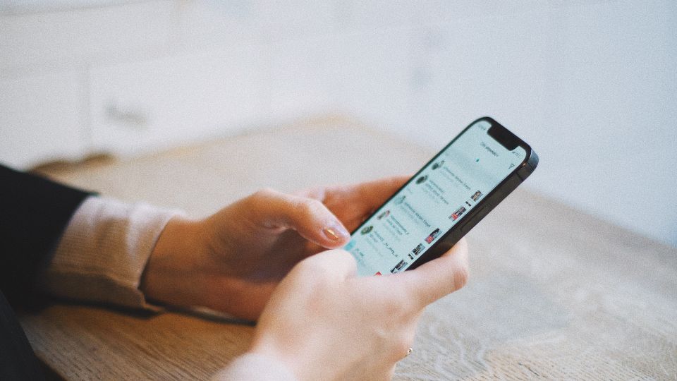 Hands holding a phone with social media content