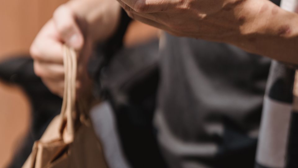 Person with shopping bags checking a smartphone