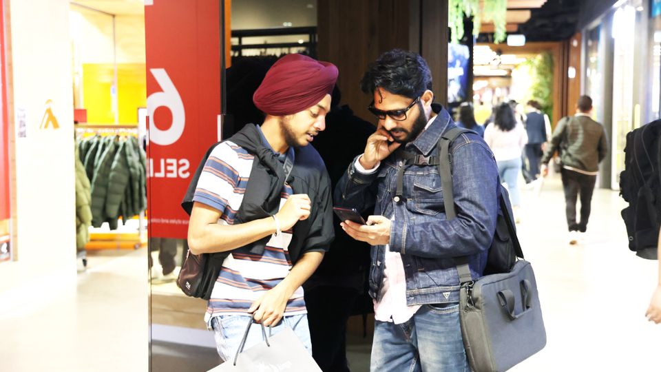 People shopping and checking a smartphone together